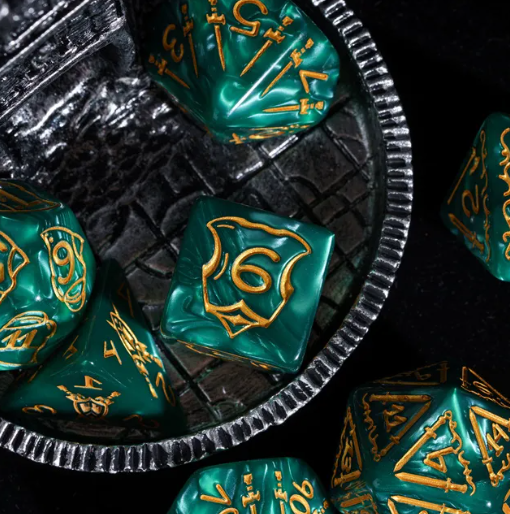 Teal polyhedral dice with gold numbering on a metallic tray against a dark background