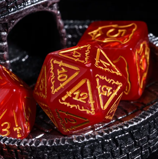 Red polyhedral dice with gold numbering on a metallic surface