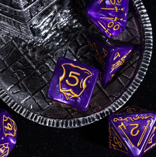 Purple dice with gold numbering on a textured black surface