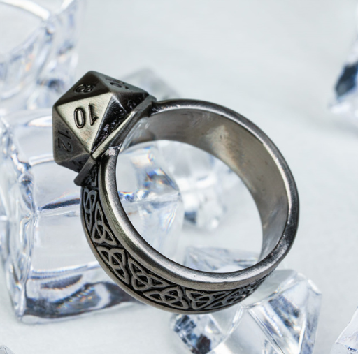 Silver ring with a dice-shaped component on a clear crystal background