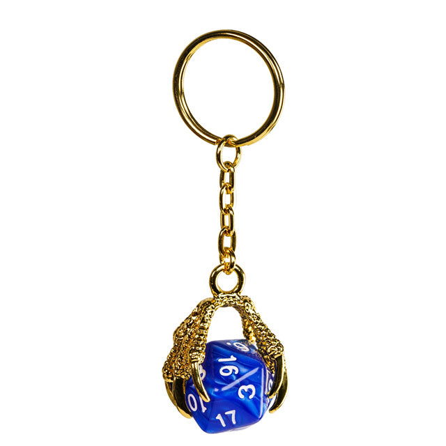 Blue polyhedral die keychain with gold cage and keyring on a white background