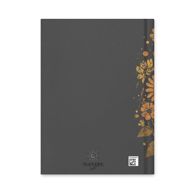 Black notebook with floral design on a white background