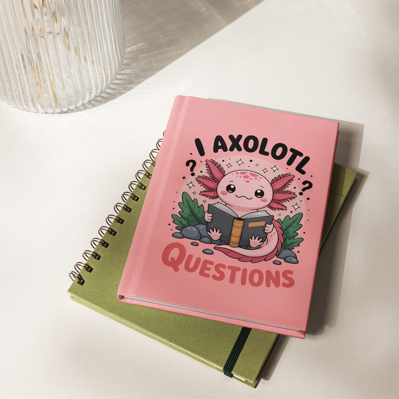 Pink notebook with axolotl illustration and text on a white surface