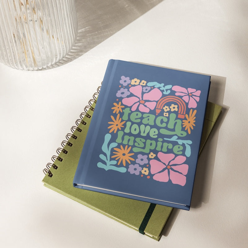 Notebook with colorful design and text 'Teach Love Inspire' on a white surface
