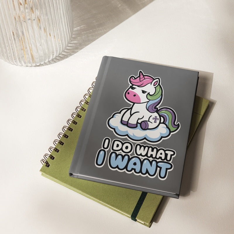 Notebook with a unicorn design and 'I Do What I Want' text on a white surface