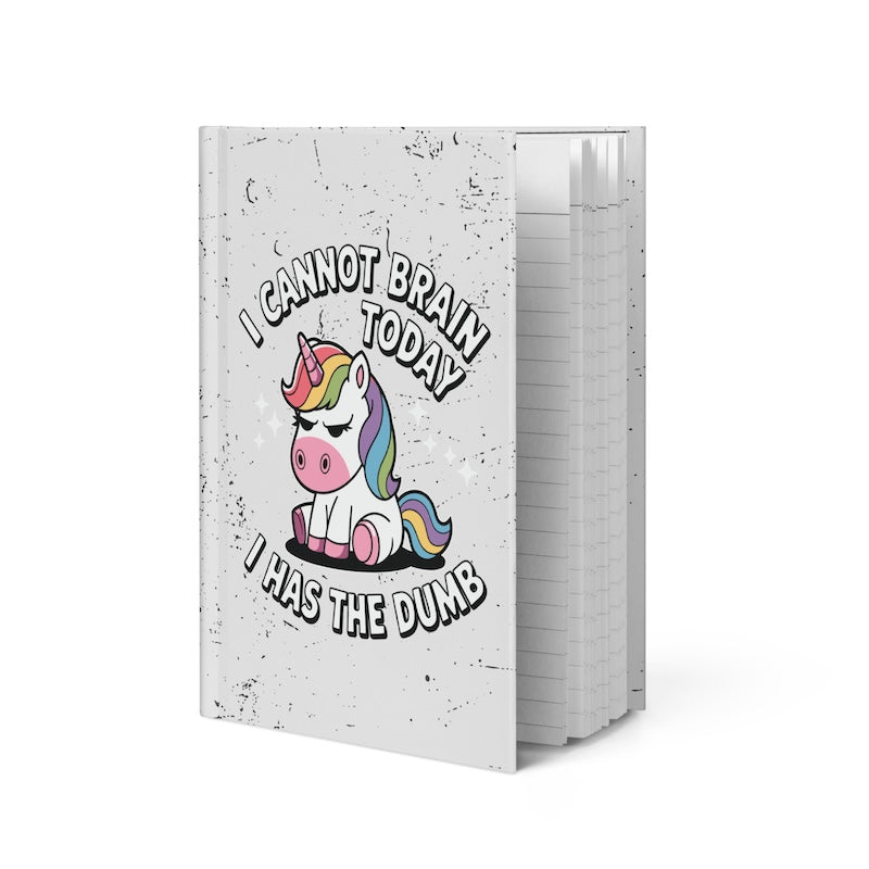 Notebook with a colorful unicorn illustration and humorous text on a white background