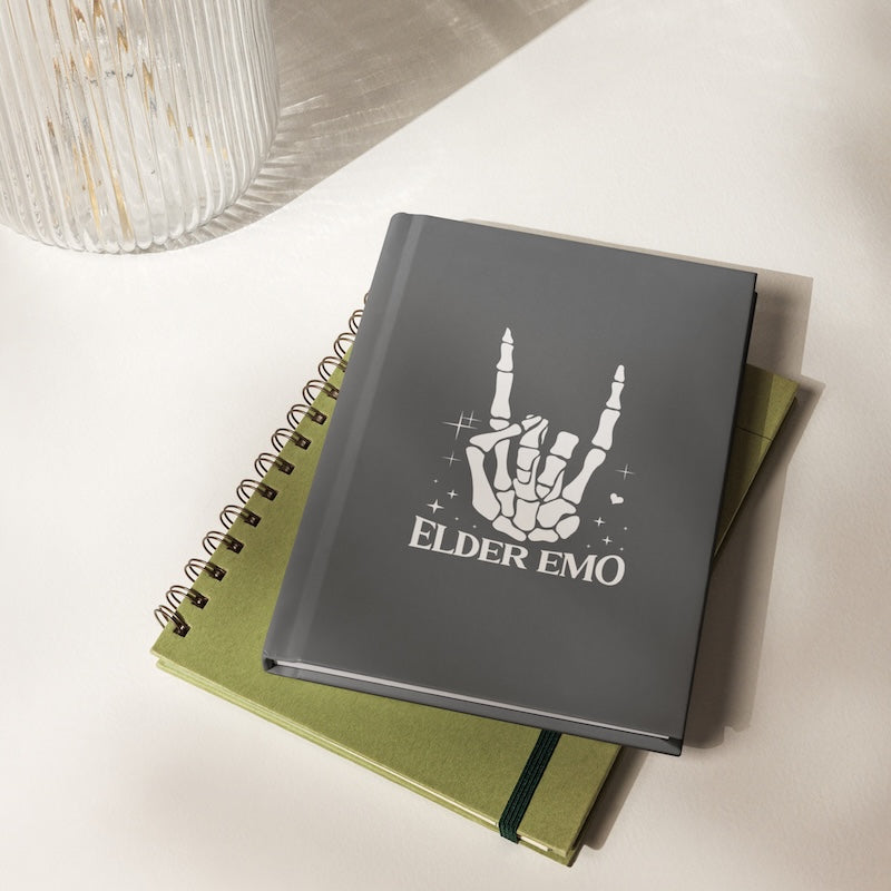 Gray notebook with 'Elder Emo' design on a green notebook