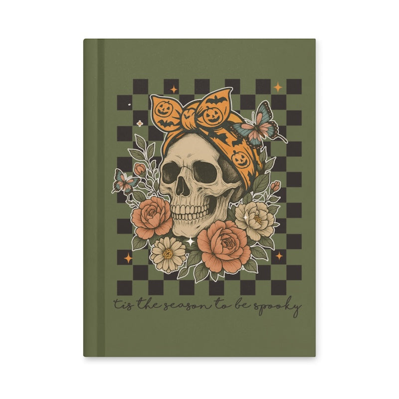 Notebook with a skull and floral design on a green and black checkered background
