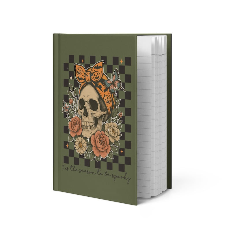 Notebook with a Halloween-themed design featuring a skull, roses, and pumpkins on a green cover.