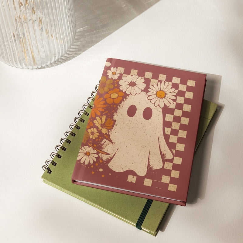 Notebook with ghost and floral design on a white surface