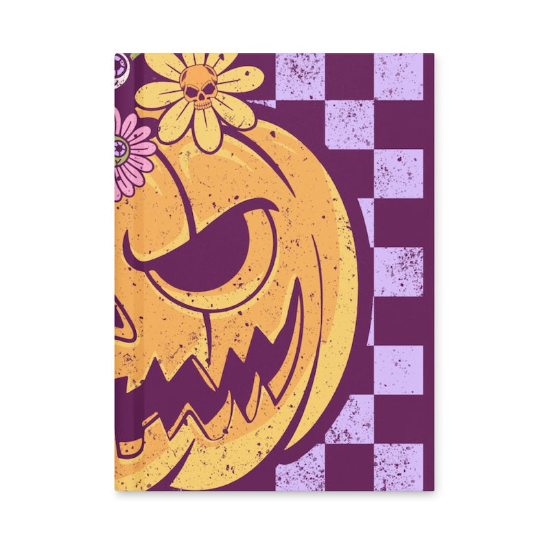 Notebook with a pumpkin and floral design on a purple and white checkered background