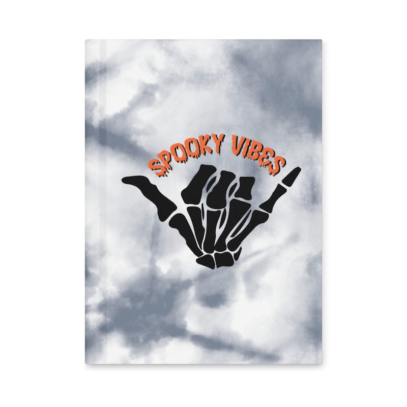 Hand with skeleton fingers making a peace sign against a cloudy sky background with 'Spooky Vibes' text.