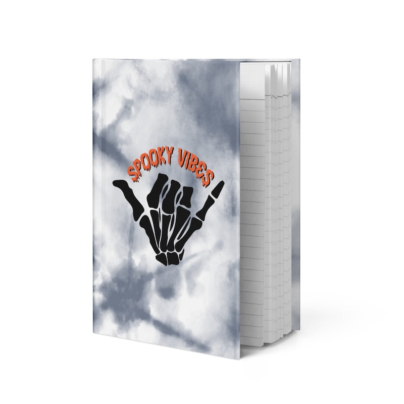 Notebook with 'Spooky Vibes' design on a cloudy sky background