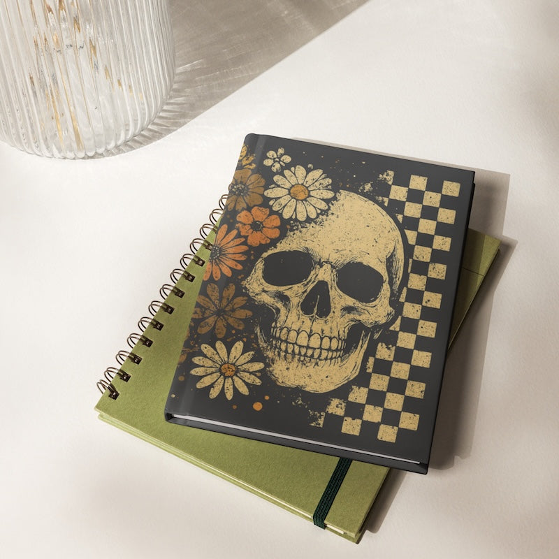 Notebook with skull and floral design on a white surface