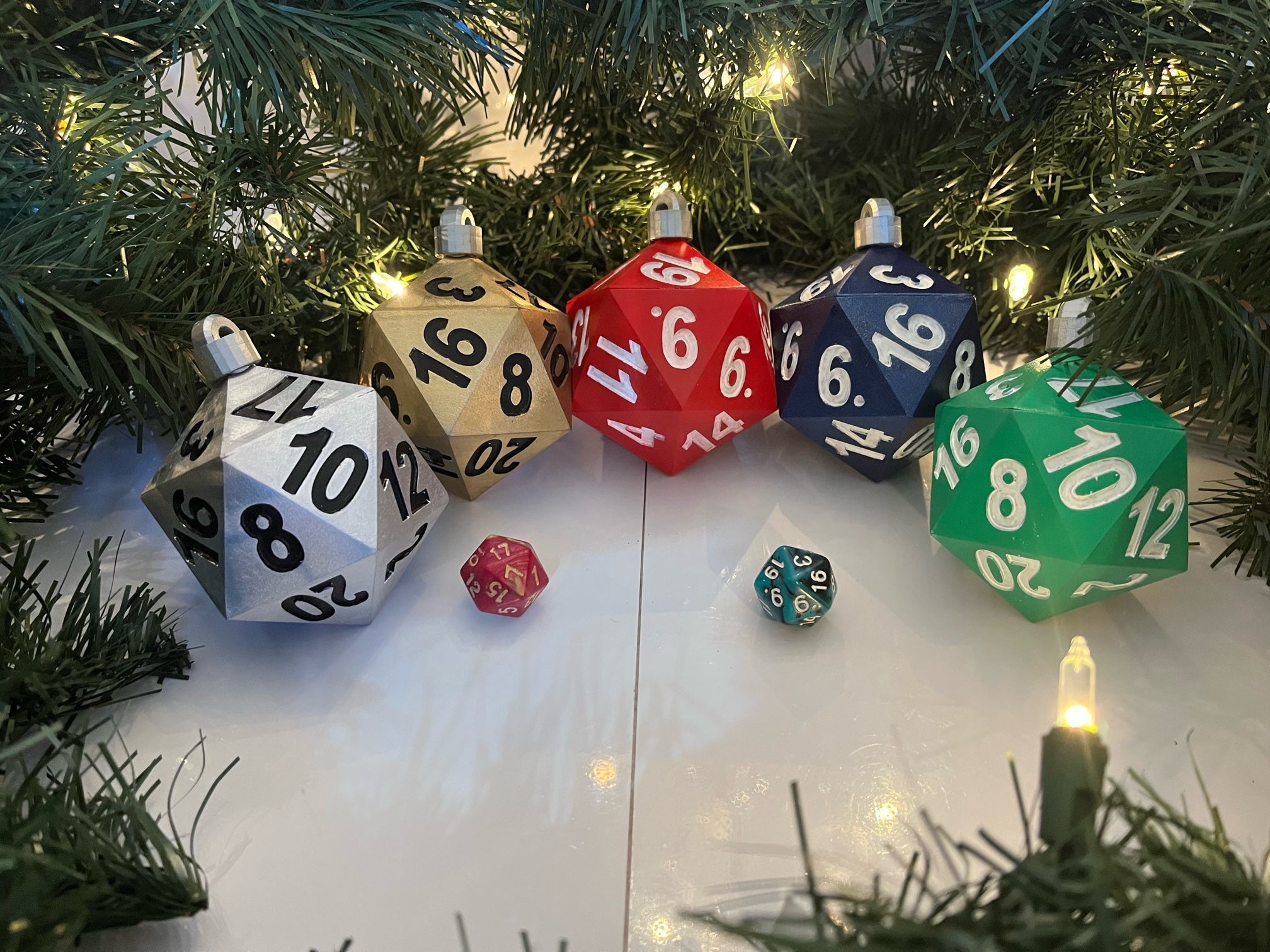 Colorful polyhedral dice ornaments on a Christmas tree with lights.