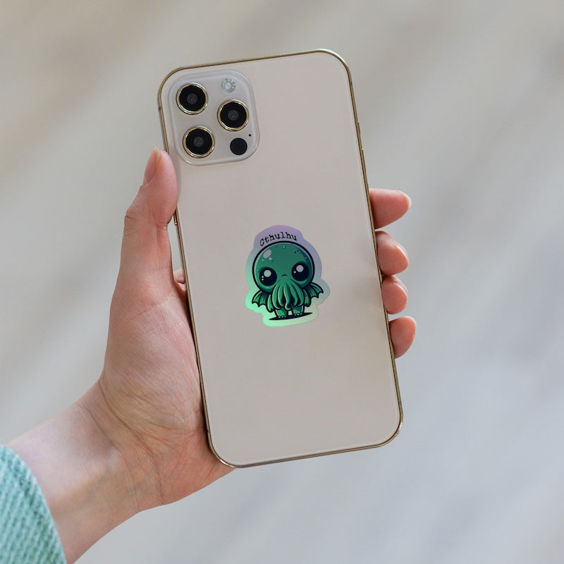 Phone case with a Cthulhu design held by a hand against a neutral background