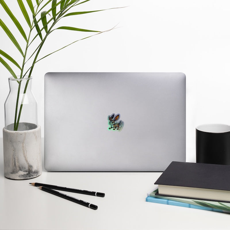 Laptop on a desk with a plant, notebook, and pencils