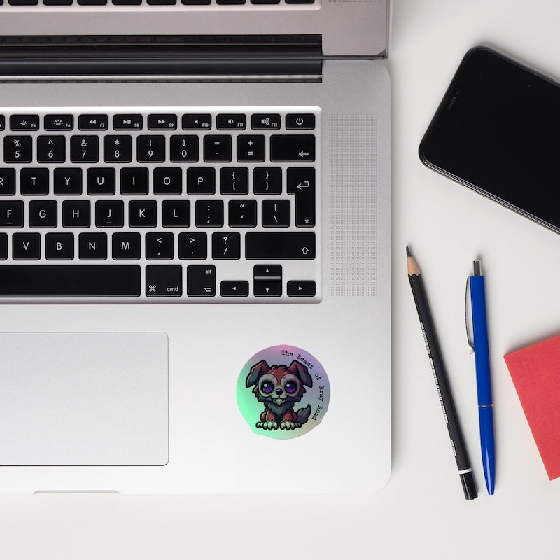 Laptop with a sticker, phone, and stationery items on a white surface