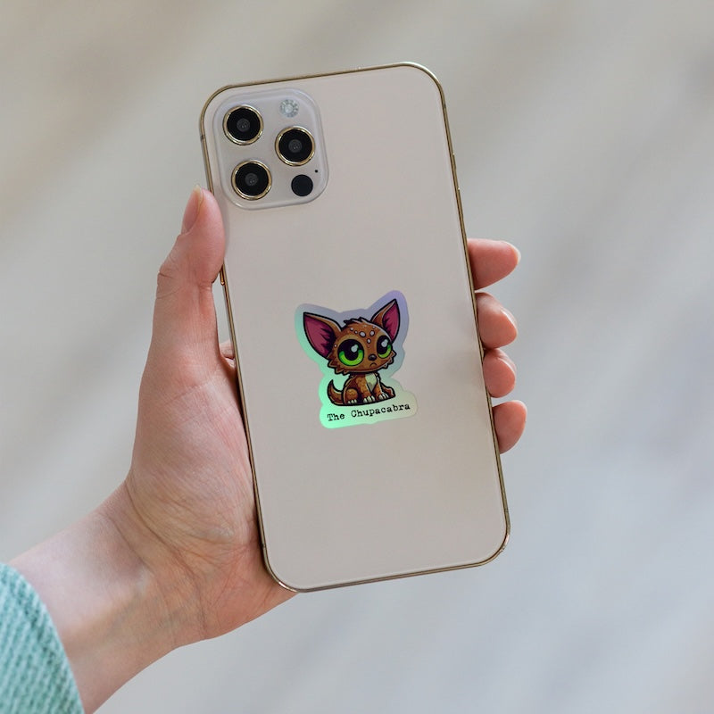 Hand holding a phone with a cartoon cat sticker on the back