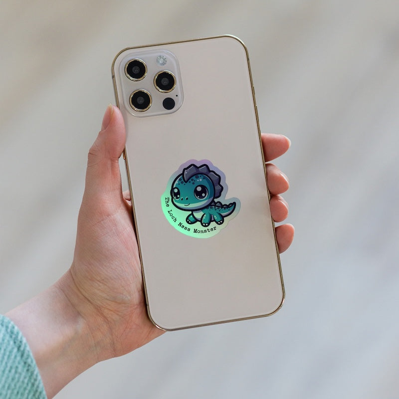 Phone case with a cute dinosaur design held by a hand against a neutral background