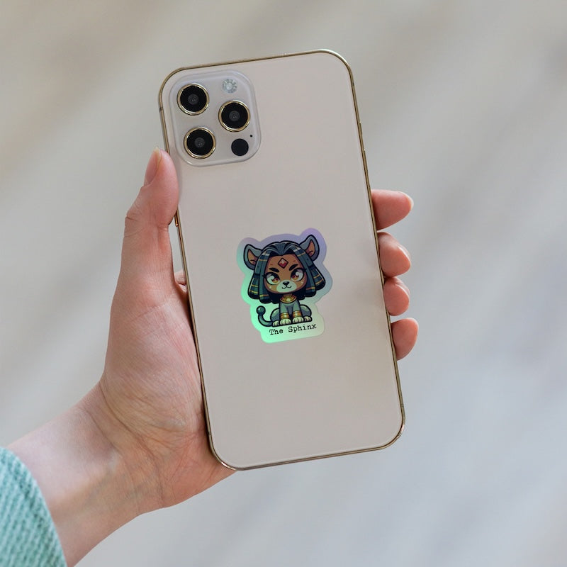 Hand holding a phone with a cartoon sticker on the back