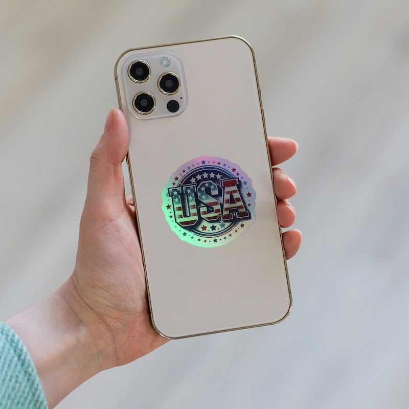 Phone case with 'USA' design held by a hand against a neutral background