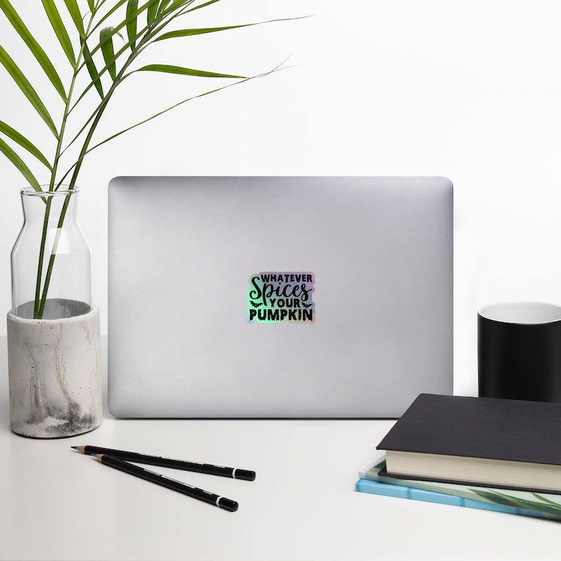 Laptop with a sticker on a desk with a plant, pencils, and books.