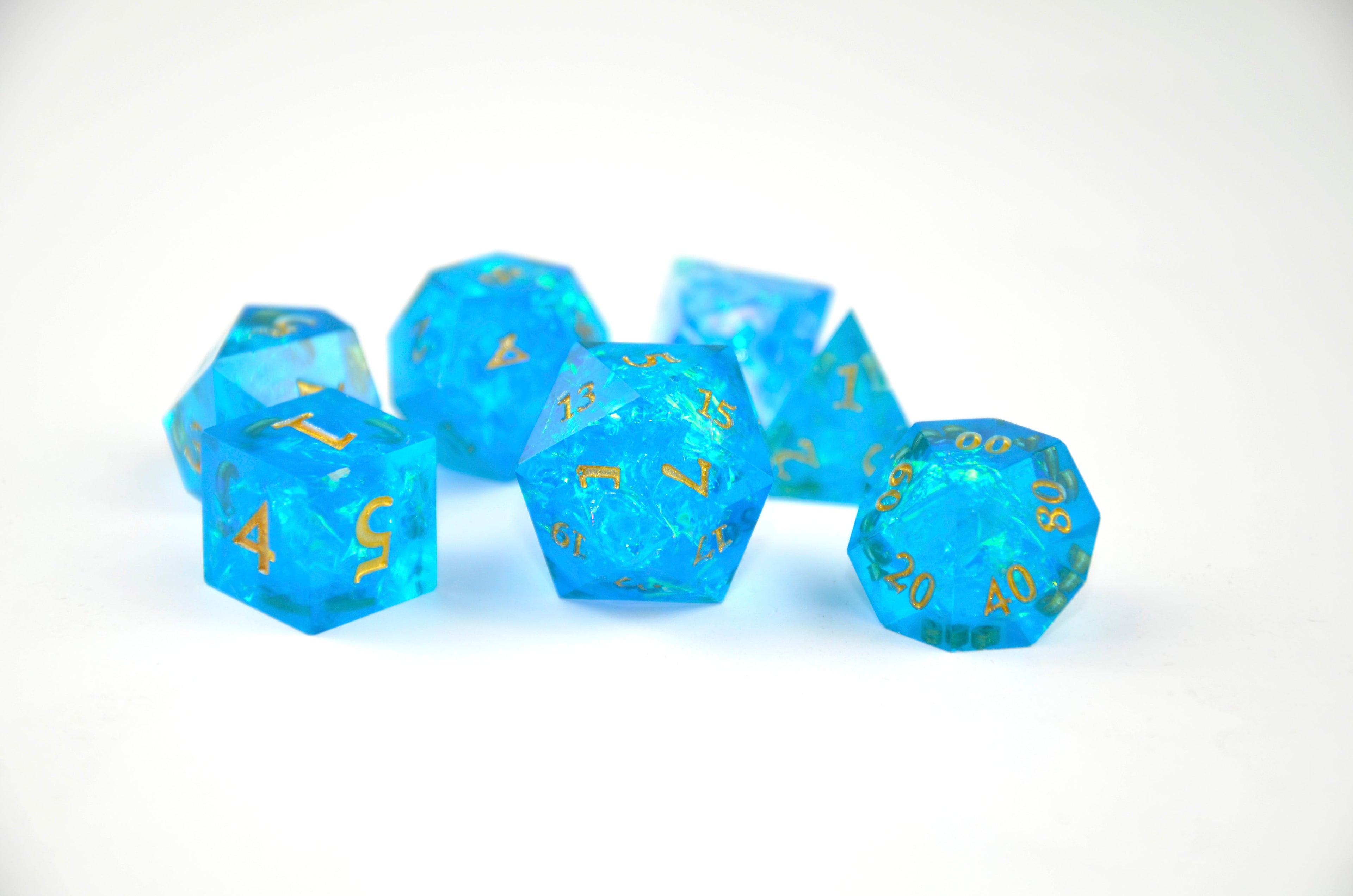 Set of blue polyhedral dice with gold numbers on a white background