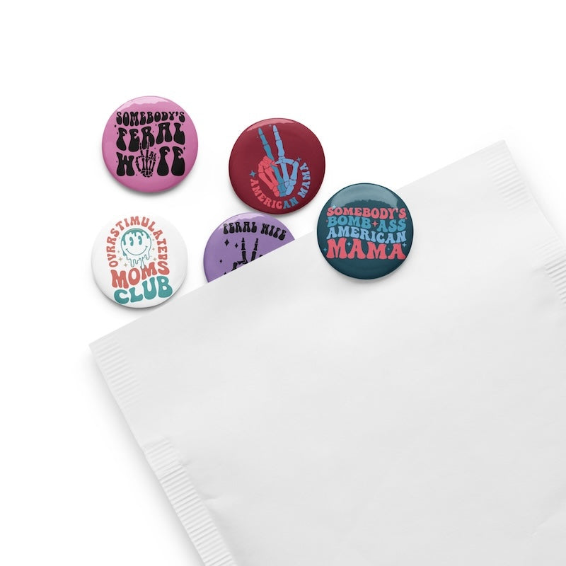Set of colorful buttons with humorous text designs on a white surface.