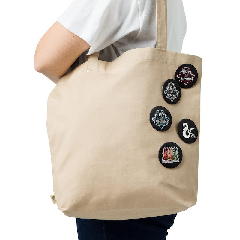 Beige tote bag with decorative pins on a white background