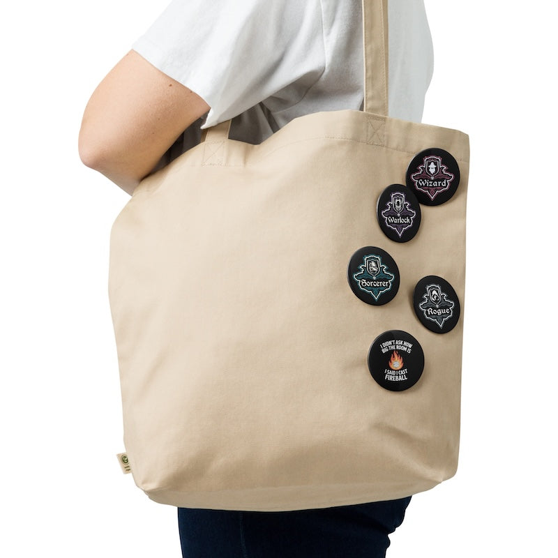 Beige tote bag with decorative buttons held by a person on a white background