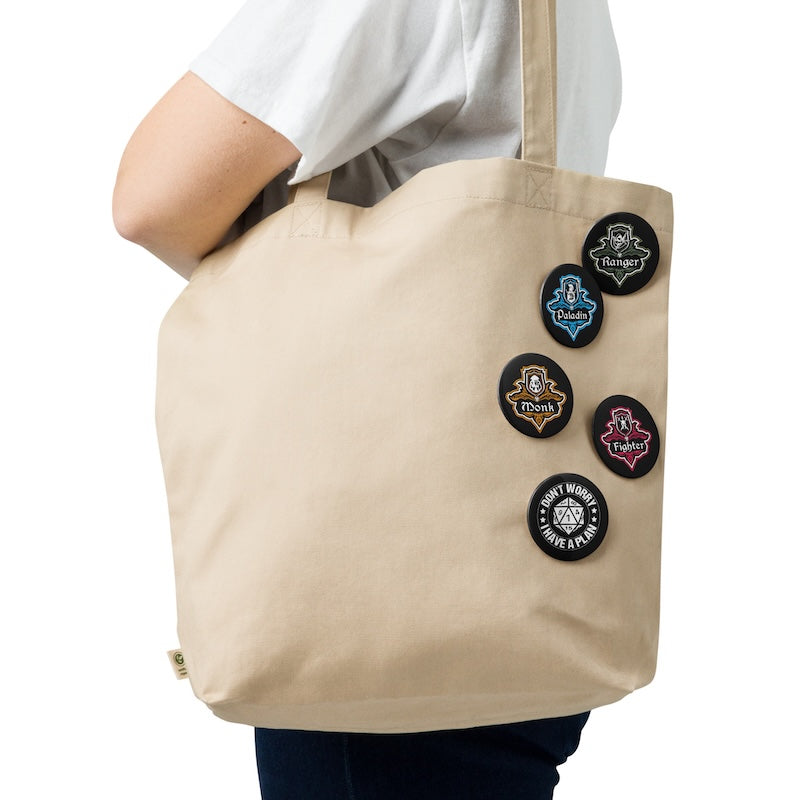 Beige tote bag with decorative buttons held by a person on a white background