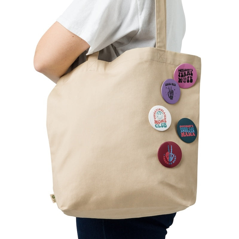 Beige tote bag with colorful buttons on a white background