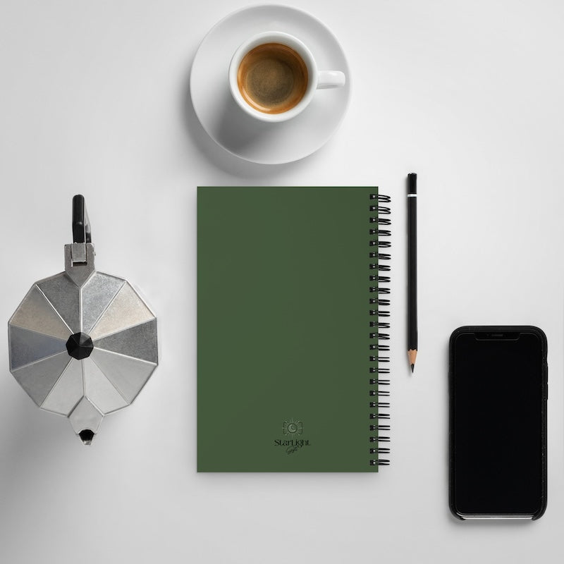 Green notebook with a pen, coffee cup, and smartphone on a light gray background