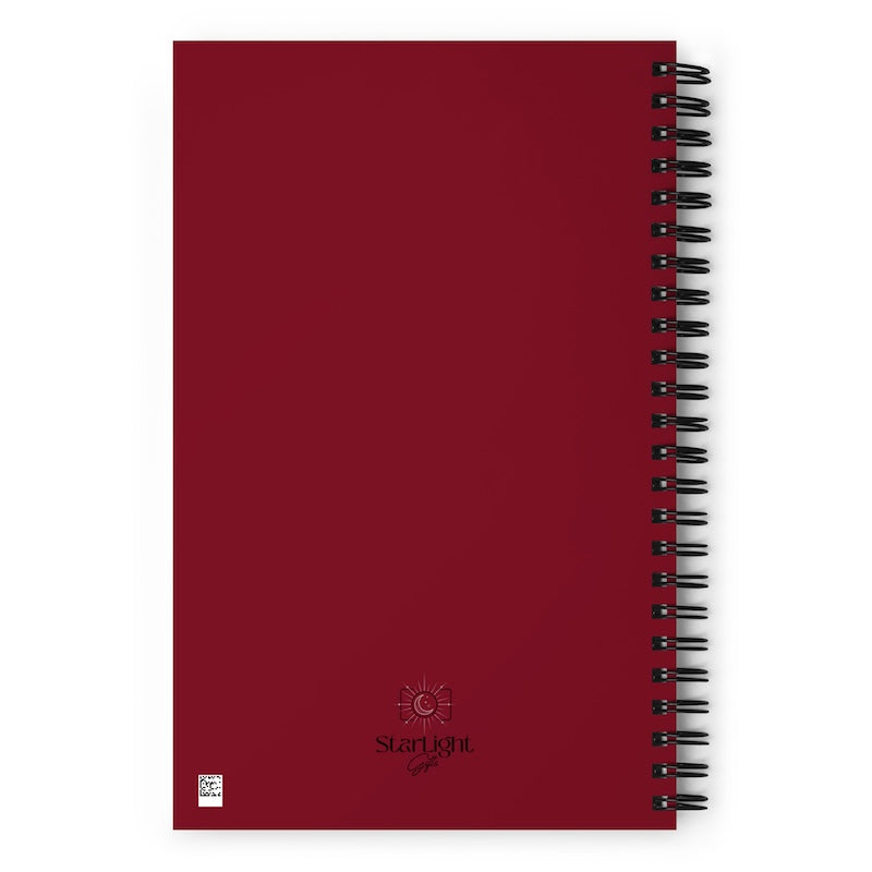 Red notebook with black spiral binding on a white background