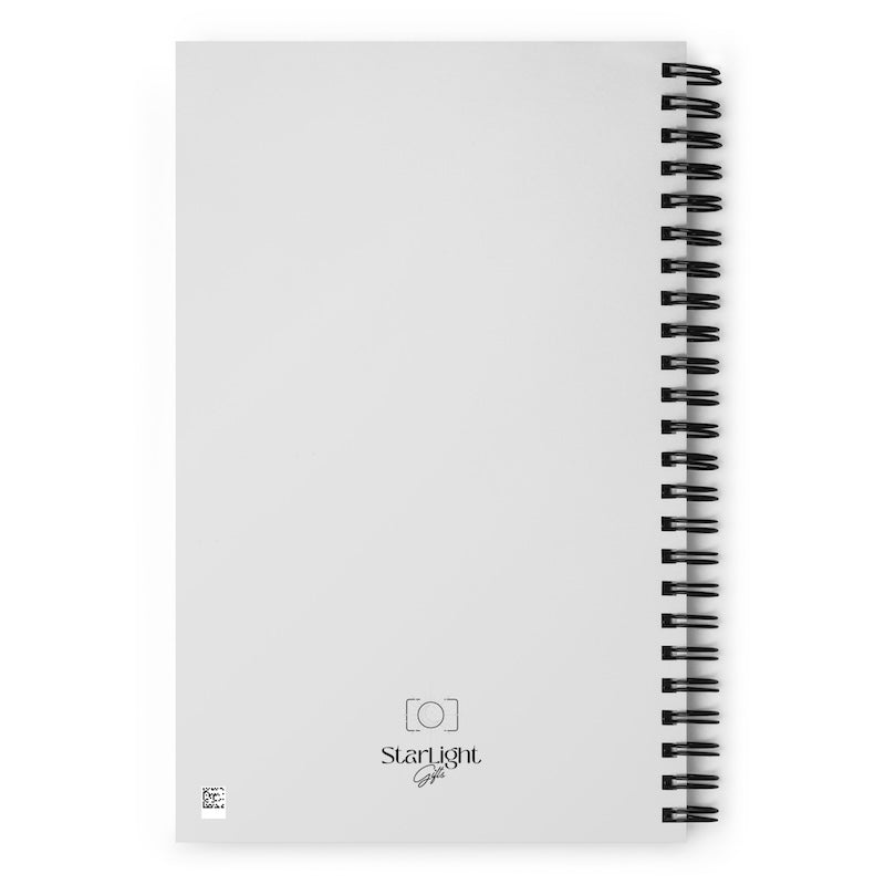 White notebook with black spiral binding on a white background