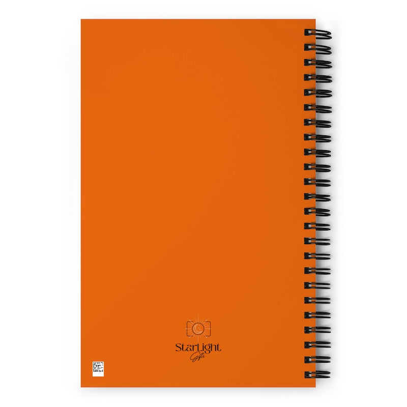 Orange notebook with spiral binding on a white background