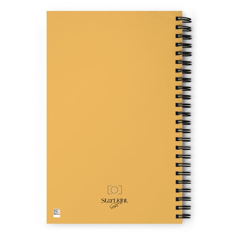 Yellow notebook with black spiral binding on a white background