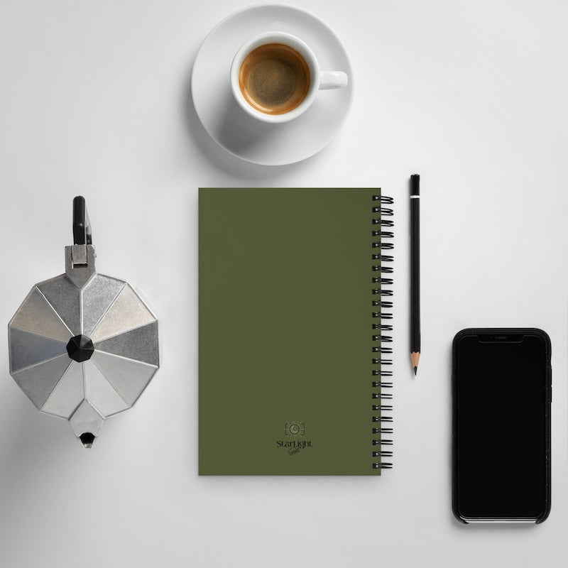 Green notebook with a pen, coffee cup, and smartphone on a light gray background