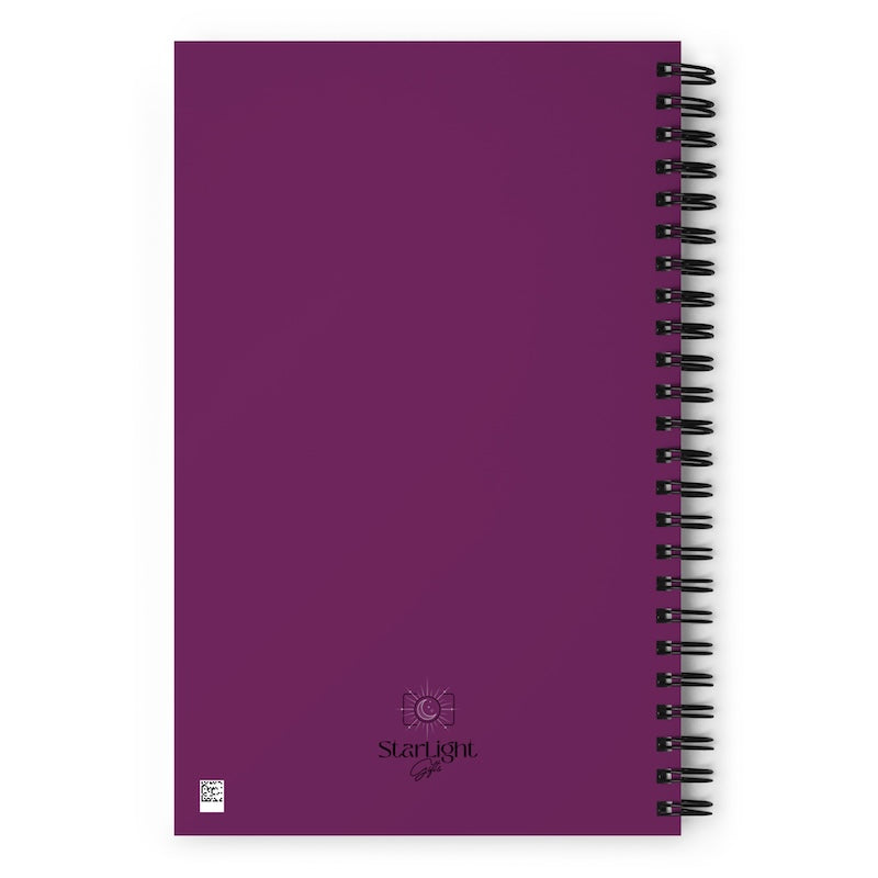 Purple notebook with black spiral binding on a white background