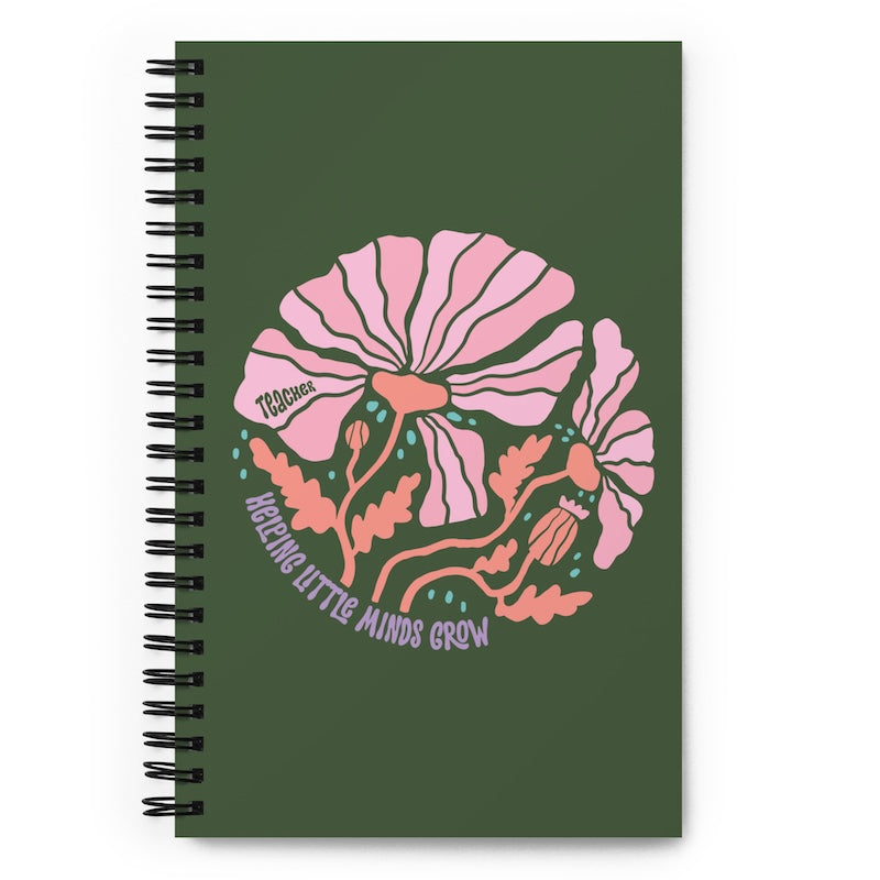 Notebook with pink floral design and text on a green background