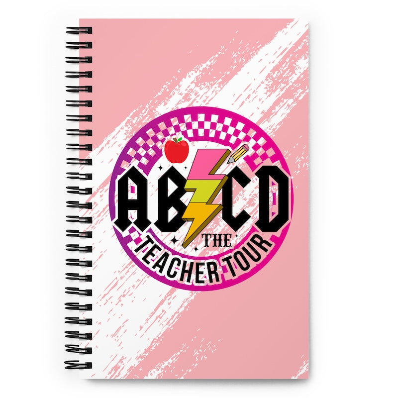 Notebook with 'ABZCD The Teacher Tour' design on a pink and white background
