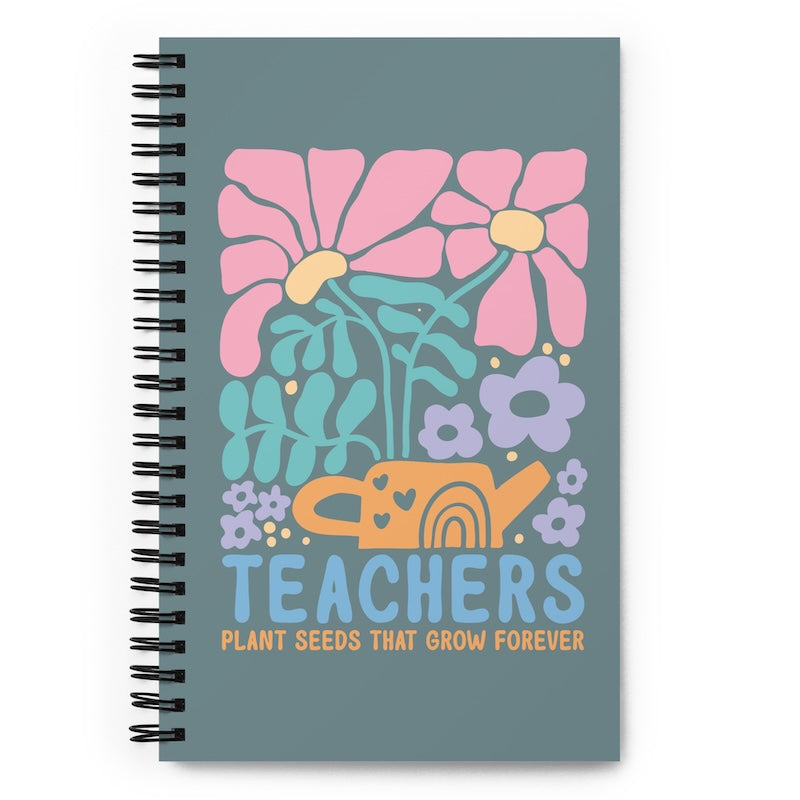 Notebook with floral design and 'Teachers Plant Seeds That Grow Forever' text on a blue background