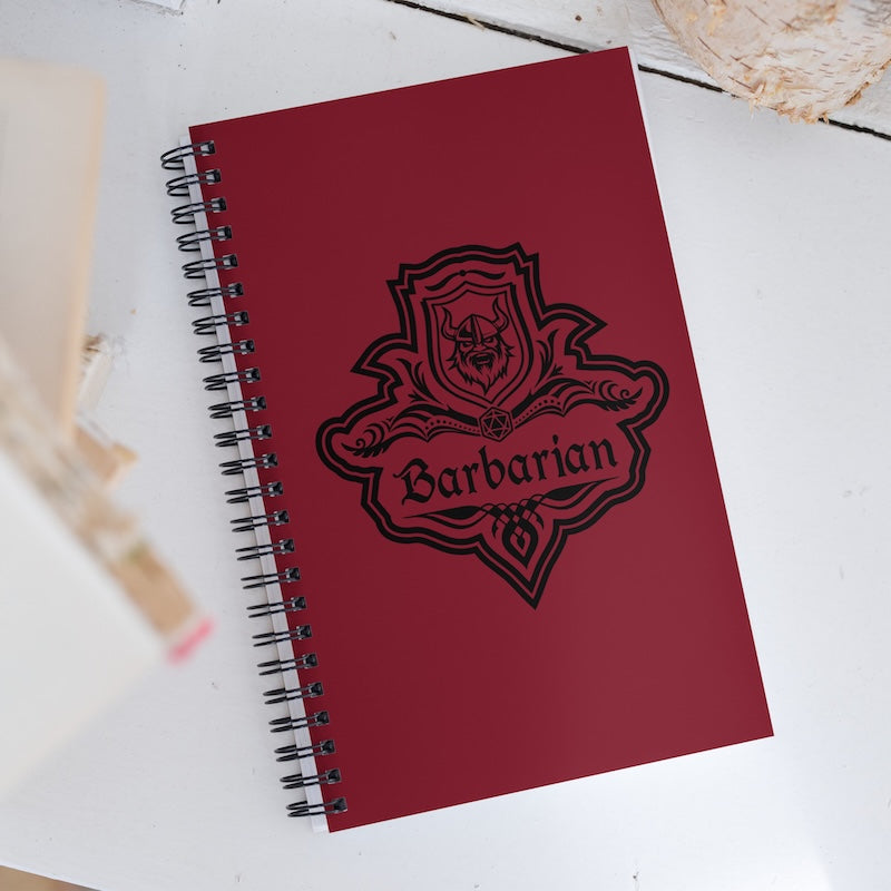 Red notebook with 'Barbarian' design on a white surface