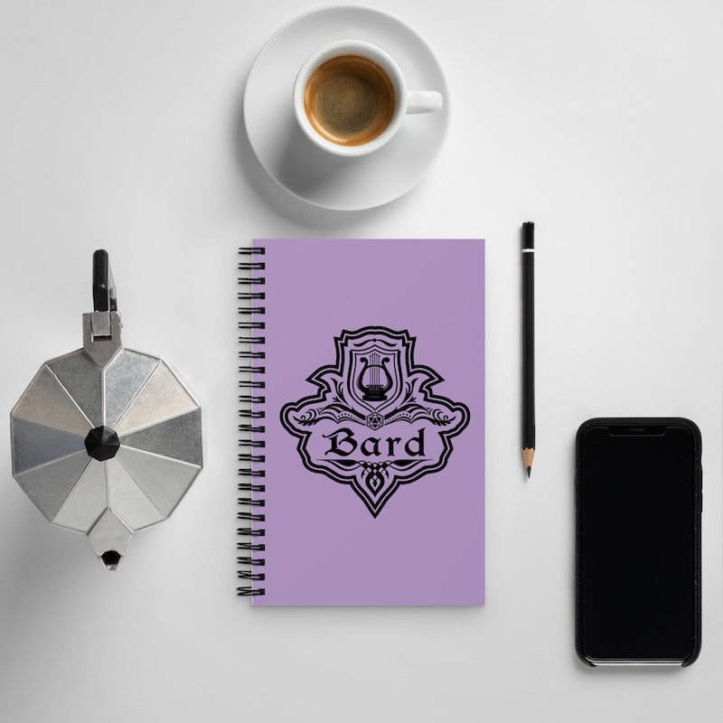 Purple notebook with 'Bard' design, coffee cup, pencil, and phone on a light gray background