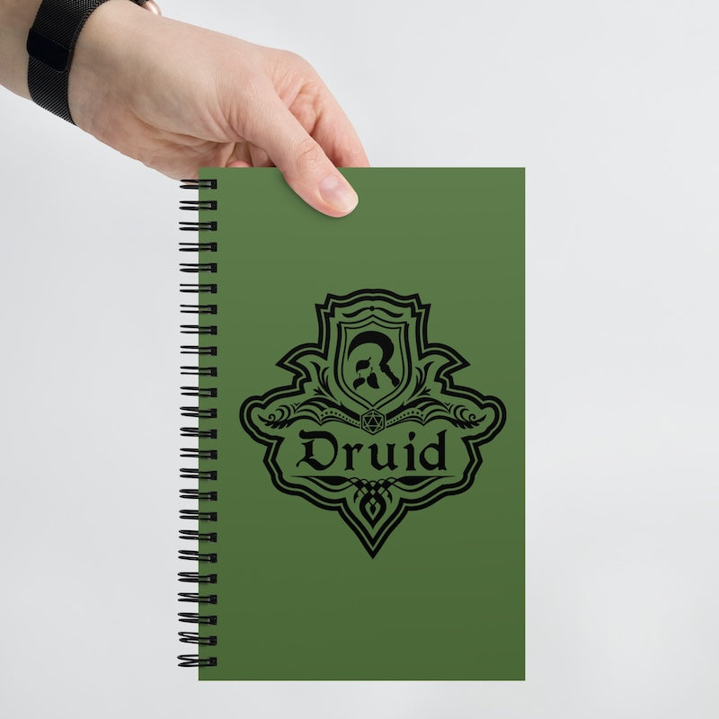 Green notebook with 'Druid' design held by a hand on a white background