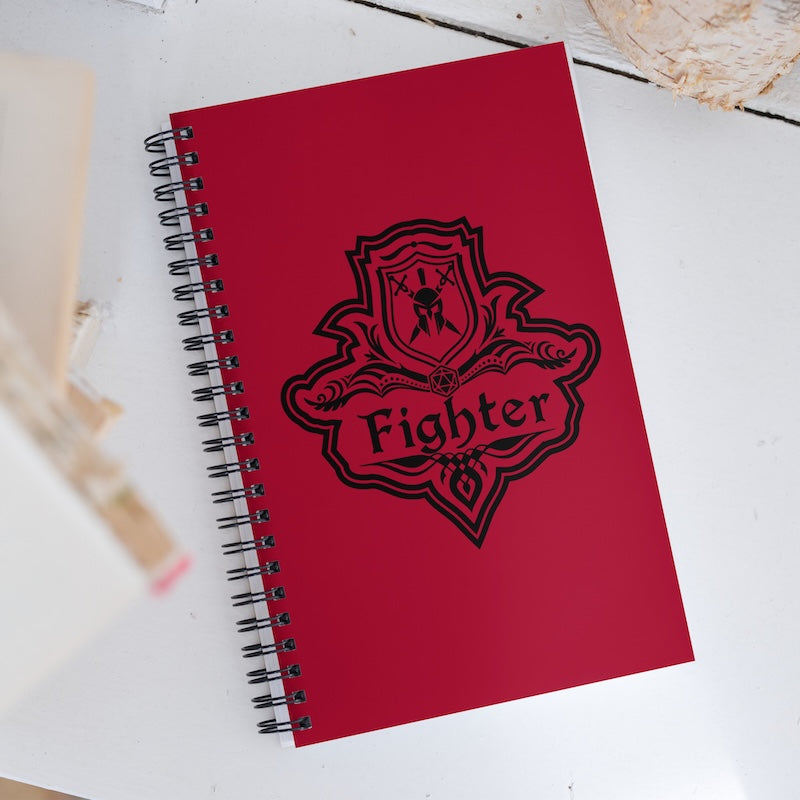 Red notebook with 'Fighter' emblem on a white surface