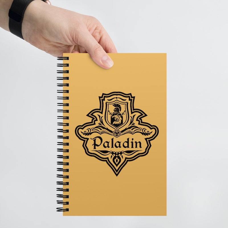 Yellow notebook with 'Paladin' logo held by a hand on a light gray background