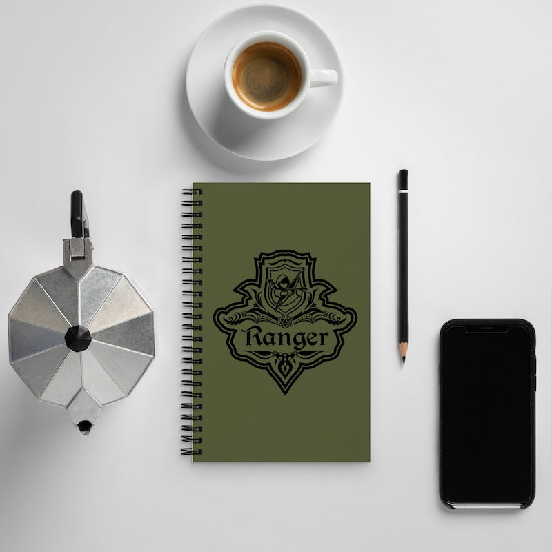 Notebook with 'Ranger' design, coffee cup, pen, and phone on a light gray background