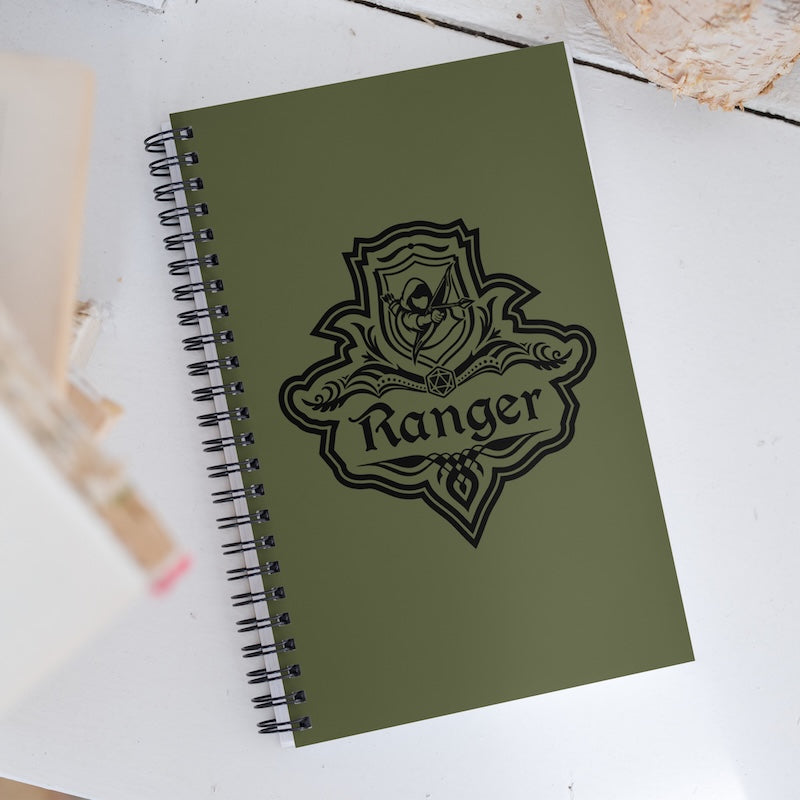 Green notebook with 'Ranger' emblem on a white surface